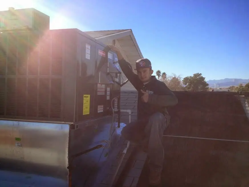 HVAC technician performing HVAC Inspection on a rooftop unit in Yorktown